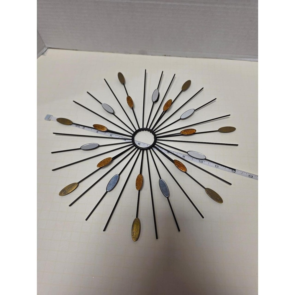starburst metal wall art piece featuring a black iron frame with silver and gold